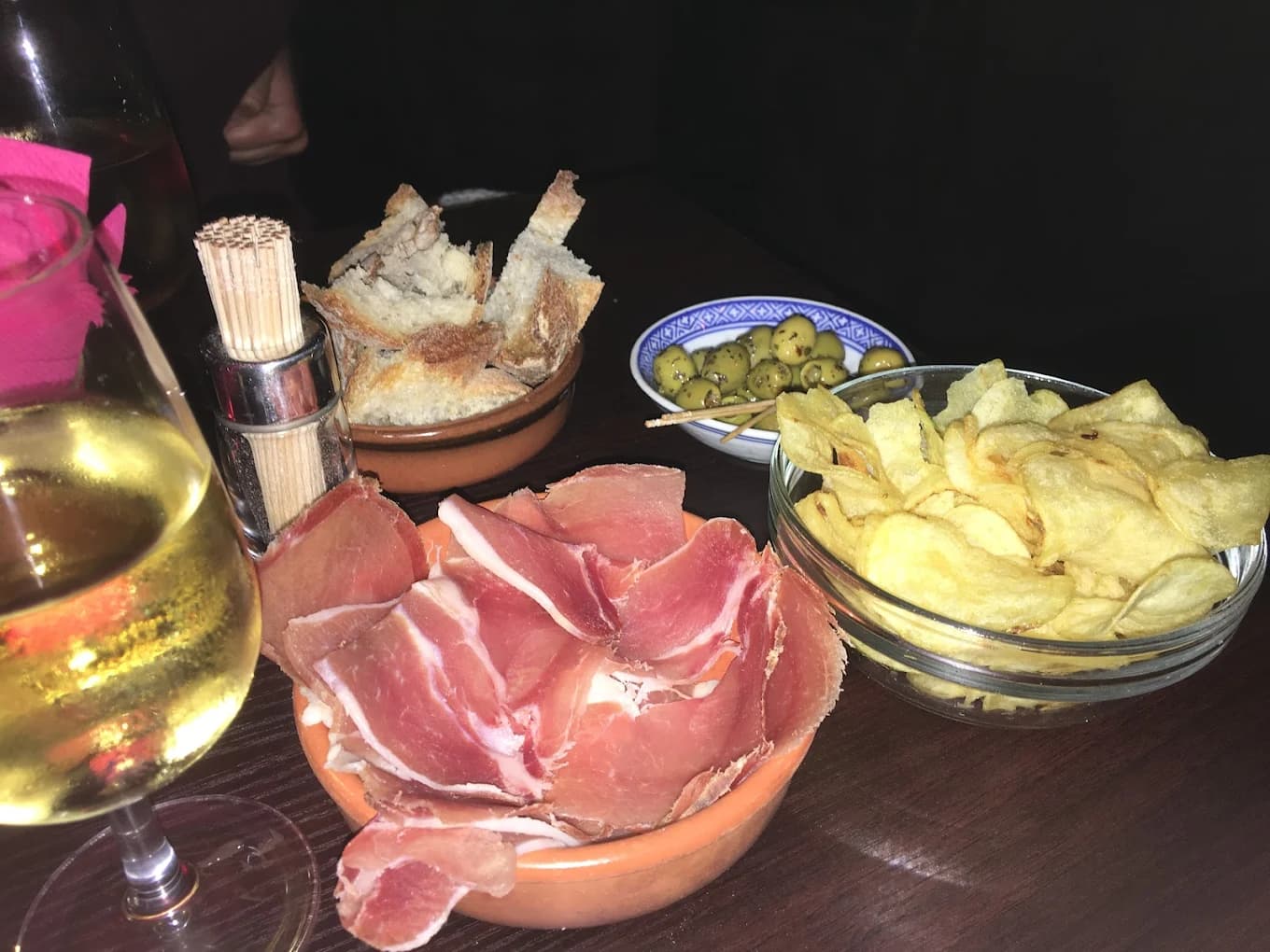Apéro du soir au Studio Café : charcuterie, olives et verre de vin blanc dans une ambiance tamisée