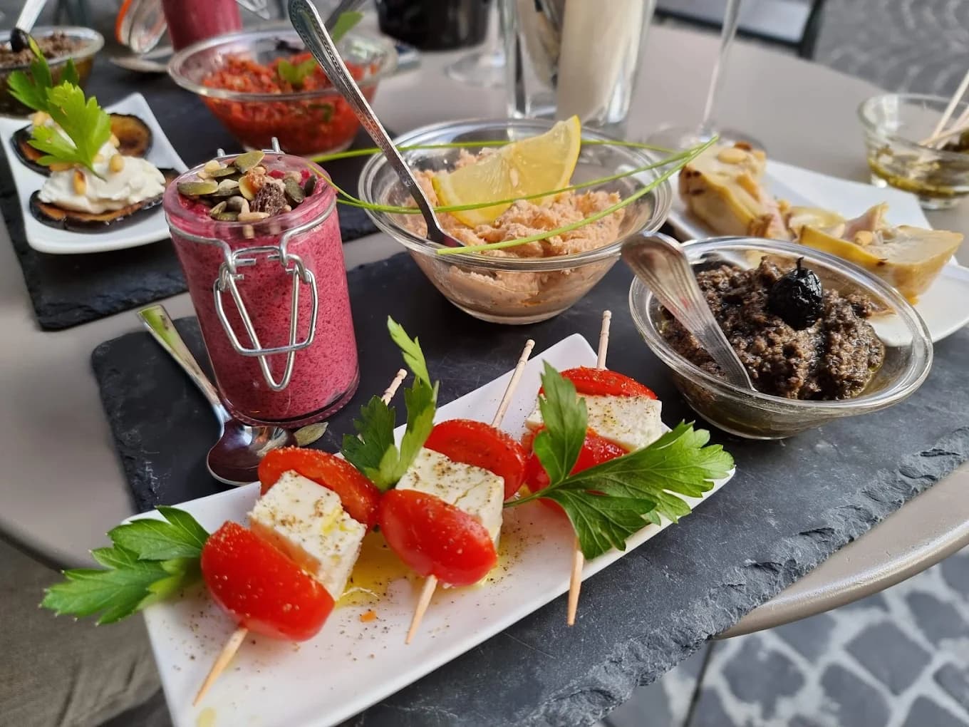 Assiette de tapas au Studio Café : brochettes feta-tomate, houmous, tapenade et gaspacho de betterave sur ardoise