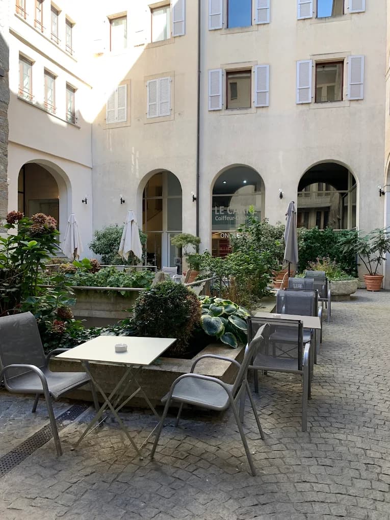Terrasse arrière du Studio Café dans une cour pavée de la vieille ville de Genève
